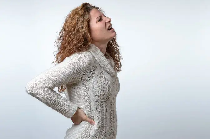 mujer sosteniendo su espalda